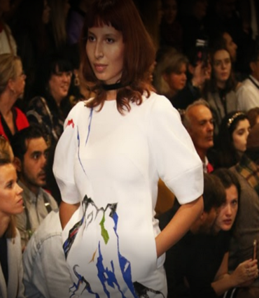 Model in a white painted dress in front of the audience