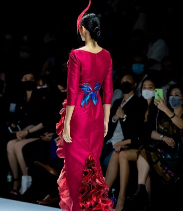 Model from behind in a crimson gown with a floral back detail