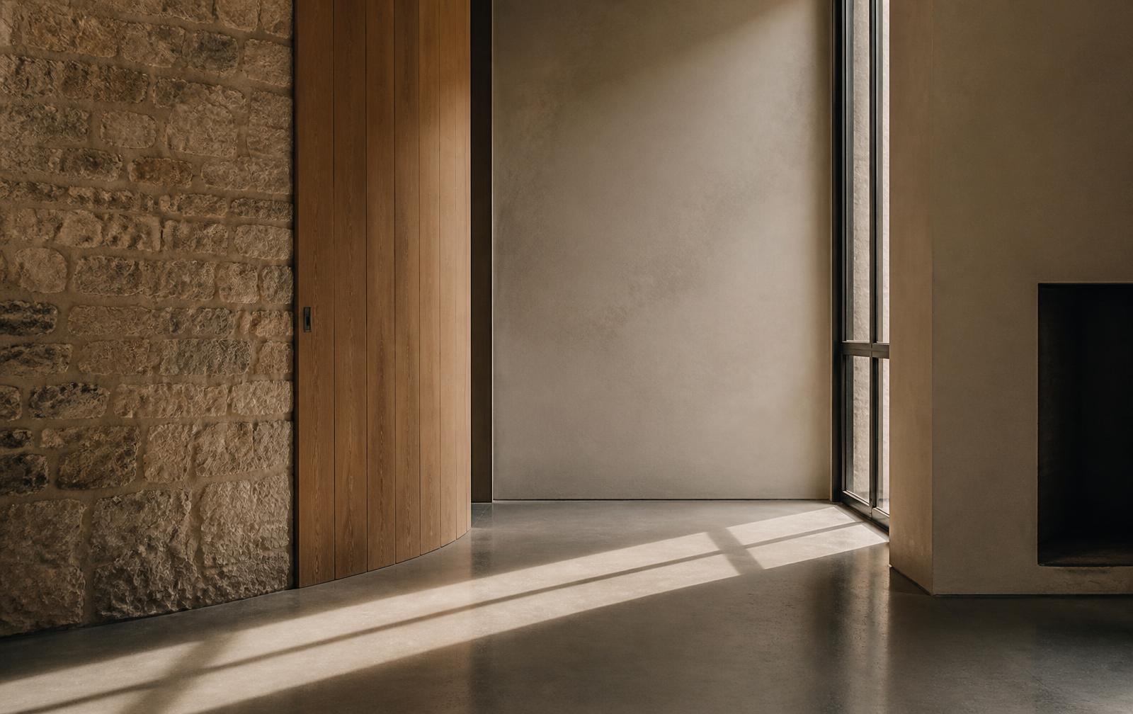 Stone, wood and plaster meeting in daylight — an architectural interior